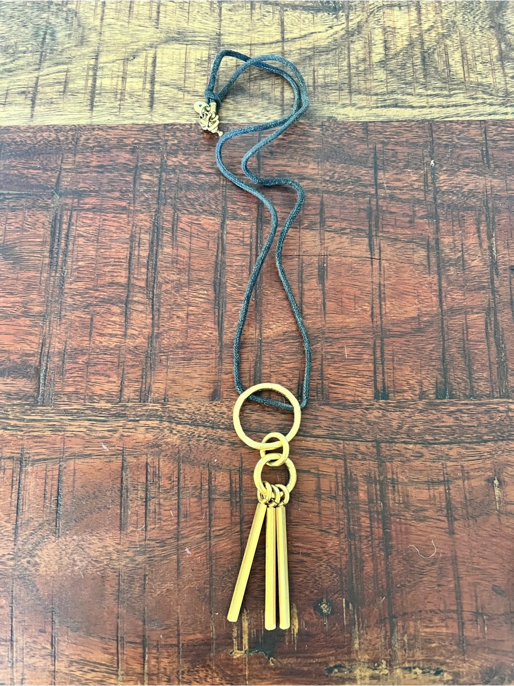 Gold Tassel Necklace on Black Cord. Costume jewelry.